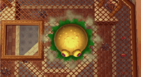 a yellow round object with eyes and green spots on a tile floor