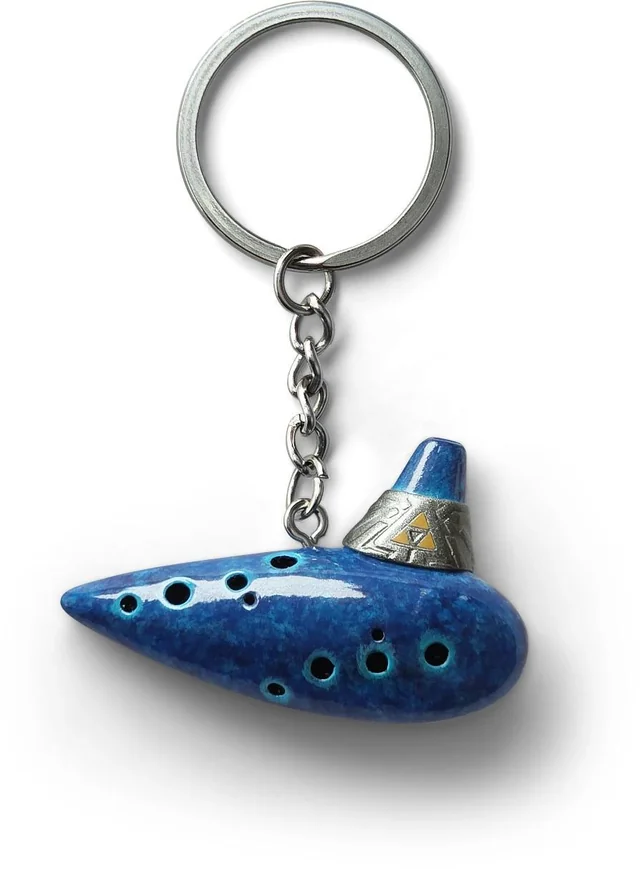 Ocarina of Time Remake Pre-Order Bonuses: Every Regional Exclusive So Far 8 Blue Ocarina of Time keychain featuring the Triforce, offered as a pre-order bonus for Ocarina of Time Remake.