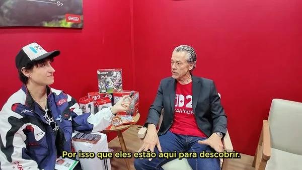 Bill van Zyll of Nintendo of Latin America speaks with interviewer Rodrigo Coelho at Brasil Game Show 2026 about demand for Zelda's 40th anniversary products.