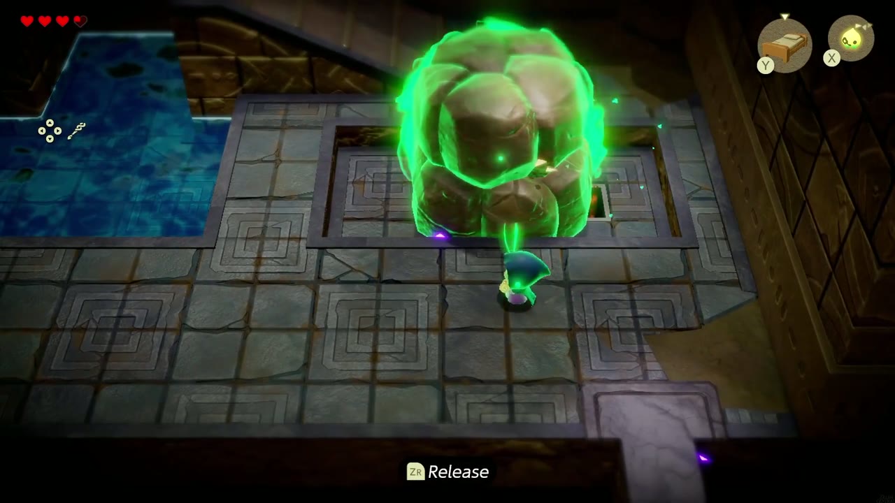 Zelda arrasta uma pedra brilhando em verde com o feitiço Bind nas Ruínas de Suthorn. Zelda arrasta uma pedra brilhando em verde com o feitiço Bind nas Ruínas de Suthorn.