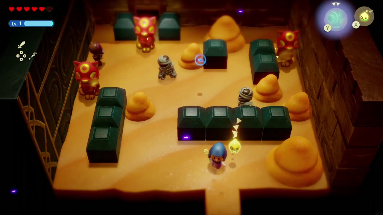Estátuas de gatos vermelhos enfeitam uma sala de areia em Gerudo Santuário onde Zelda luta contra inimigos múmias. Estátuas de gatos vermelhos enfeitam uma sala de areia em Gerudo Santuário onde Zelda luta contra inimigos múmias.