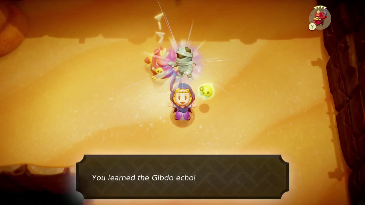 Zelda aprende o eco Gibdo em uma sala de areia iluminada por tochas na Caverna Enigmática. Zelda aprende o eco Gibdo em uma sala de areia iluminada por tochas na Caverna Enigmática.