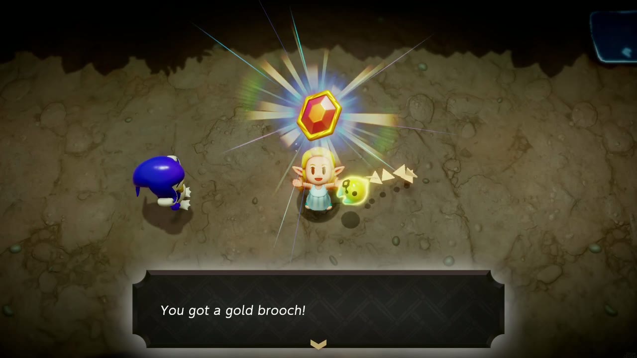 Zelda holds up the red Gold Brooch next to Rogma in the Zora Cove cave Zelda holds up the red Gold Brooch next to Rogma in the Zora Cove cave