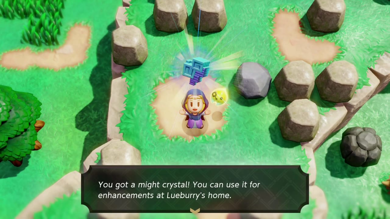 Zelda holds a might crystal overhead on a sandy patch ringed by boulders, the 'You got a might crystal!' box below