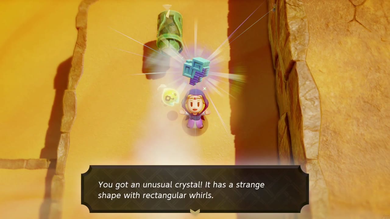 Zelda holds up an unusual crystal in a walled sand corridor in Gerudo Desert, a Wind Cannon echo behind her