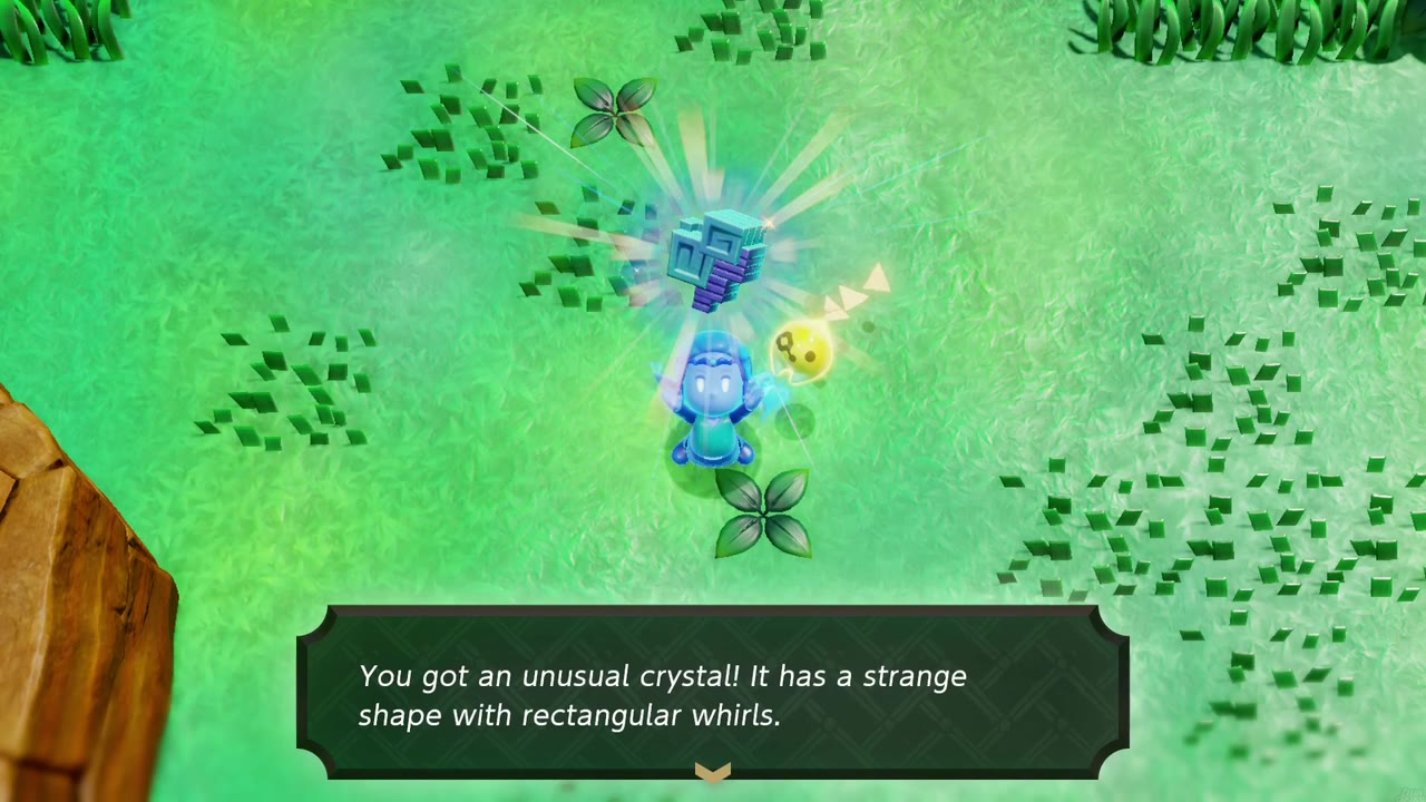 Zelda in glowing Swordfighter Form holds up an unusual crystal in a cut grass field beside a red-rock cliff