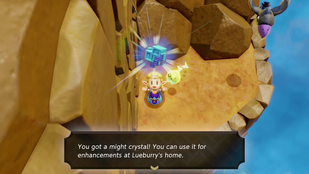 Zelda holds a might crystal overhead on a sandy cliff ledge above the sea, under tall brown boulders.
