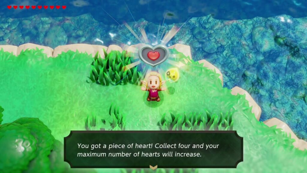 Zelda hält das Herzteil auf dem grasbewachsenen Vorsprung neben dem Burggraben hoch.