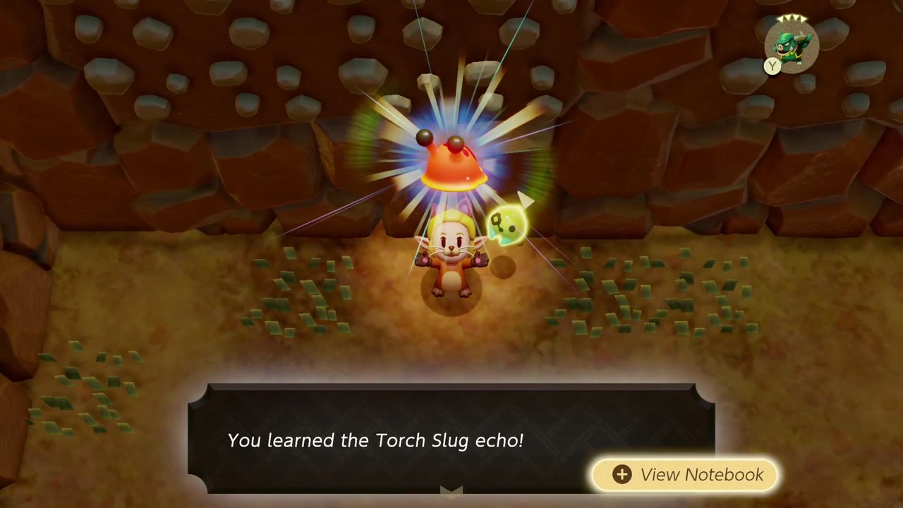 Zelda aprende o eco da Lesma Tocha ao pé de uma parede rochosa na Trilha do Vulcão Eldin. Zelda aprende o eco da Lesma Tocha ao pé de uma parede rochosa na Trilha do Vulcão Eldin.