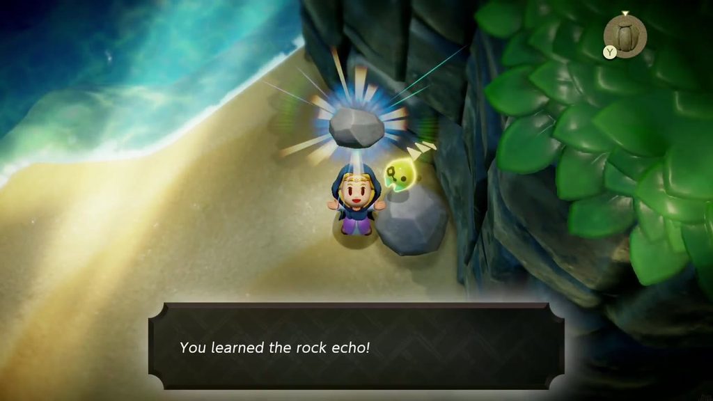Zelda holds up a rock as she learns the Rock echo on the sand of the waterfall basin