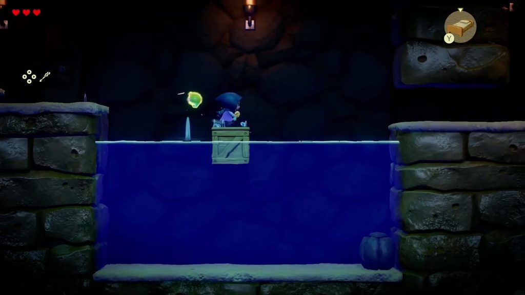Zelda stands on a floating Wooden Box to cross the water in the underground waterway