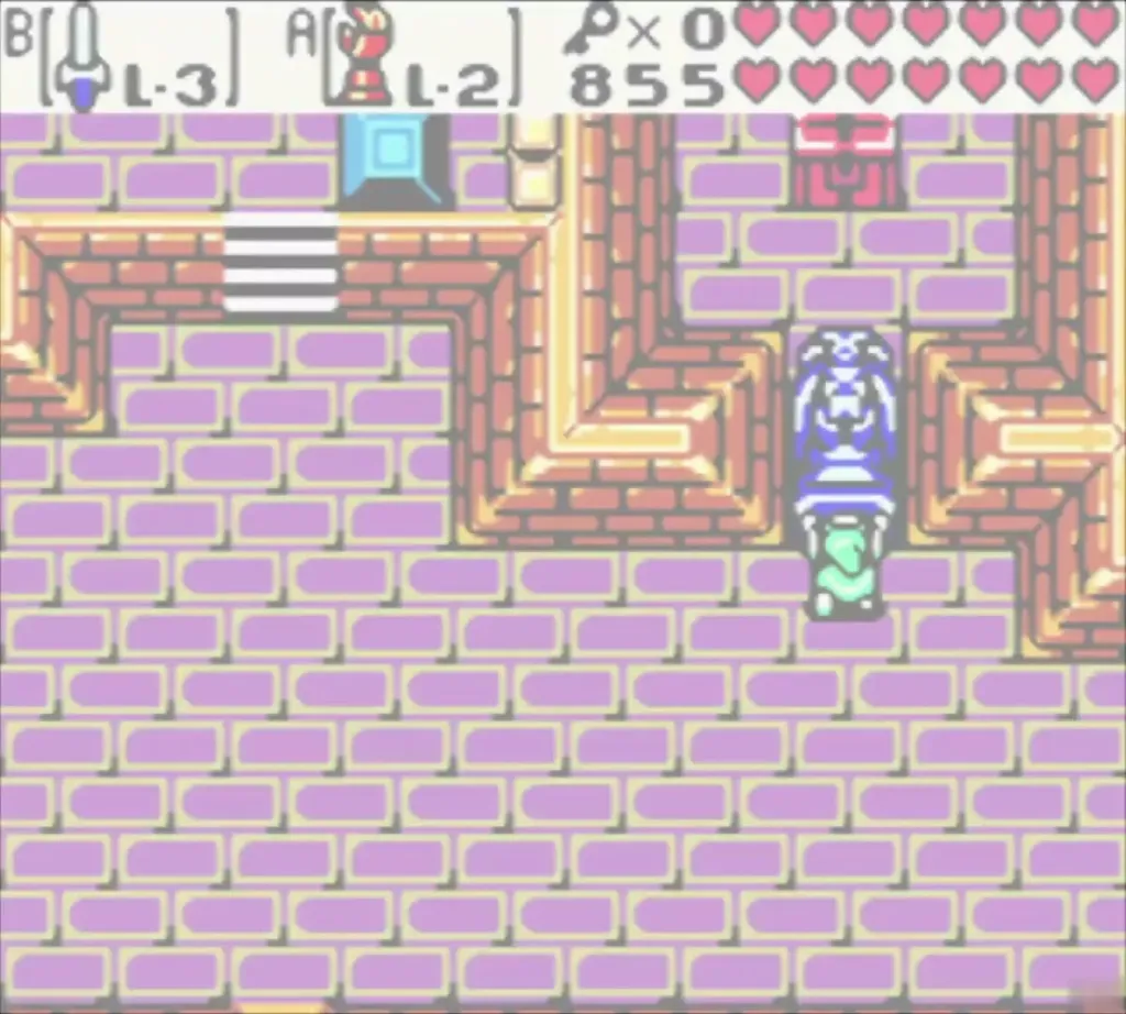 Link below a blue statue and the stairs in a basement room of the Ancient Tomb Link below a blue statue and the stairs in a basement room of the Ancient Tomb
