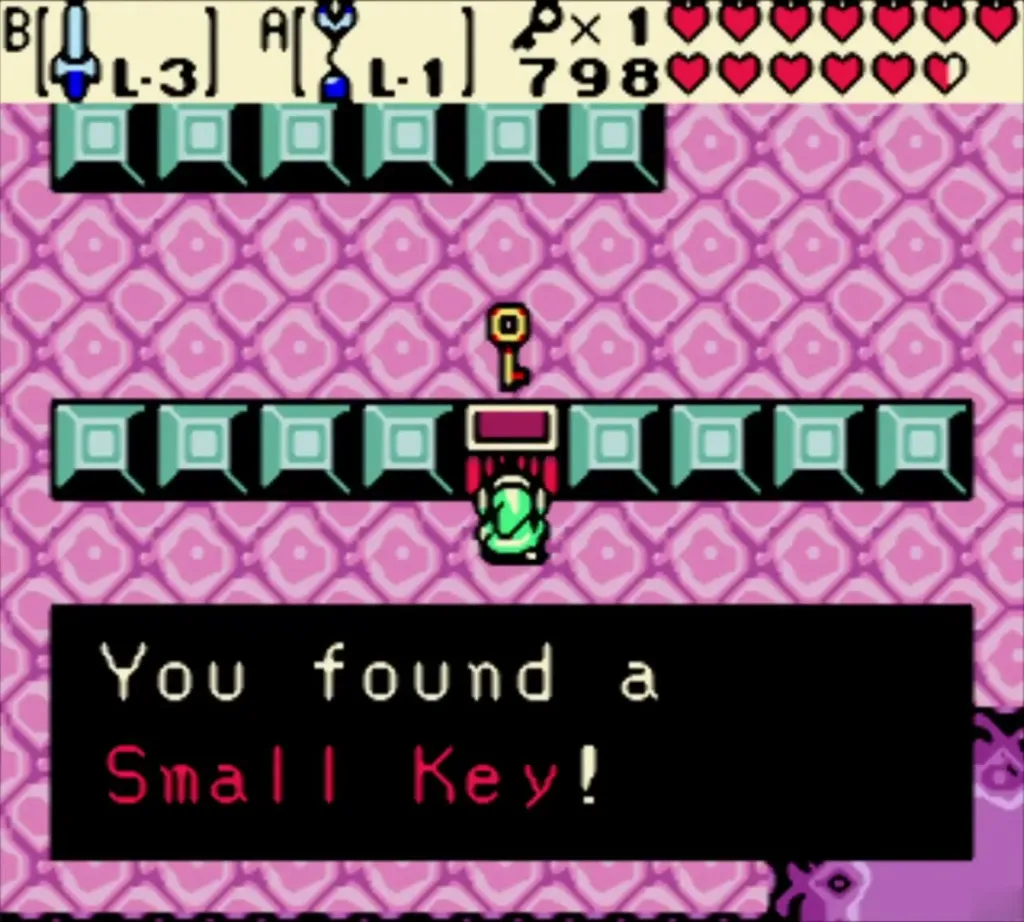 Link holding up a Small Key in a pink room of teal blocks in Jabu-Jabu's Belly