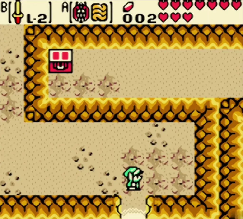 Link in a sandy orange-walled room of the Goron cave beside a red chest Link in a sandy orange-walled room of the Goron cave beside a red chest