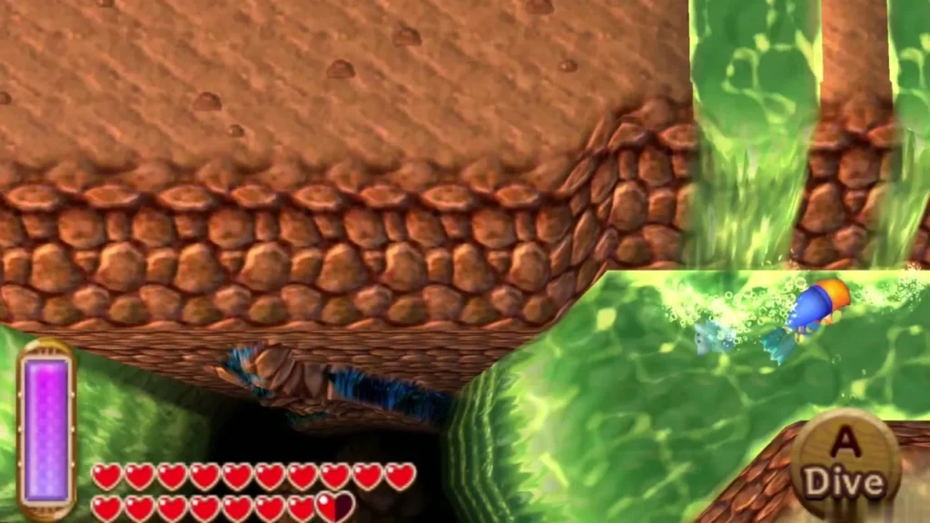 Link swimming toward a cobbled brown wall where two green waterfalls pour into a pool, the Dive prompt on screen Link swimming toward a cobbled brown wall where two green waterfalls pour into a pool, the Dive prompt on screen