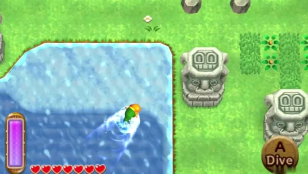 Link swimming in a water channel beside a stone head statue, with the A Dive prompt showing