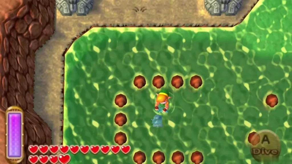 Link swimming in green water inside a C-shaped ring of brown rock stumps, with the Dive prompt on screen Link swimming in green water inside a C-shaped ring of brown rock stumps, with the Dive prompt on screen