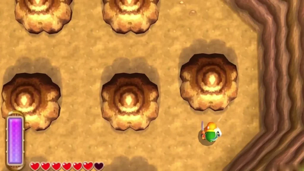 Link with his sword drawn on sandy ground beside a field of round brown rock formations and a cliff Link with his sword drawn on sandy ground beside a field of round brown rock formations and a cliff