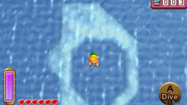 Link diving in the middle of a ring of pale shallow water on the lake, with the Dive prompt on screen