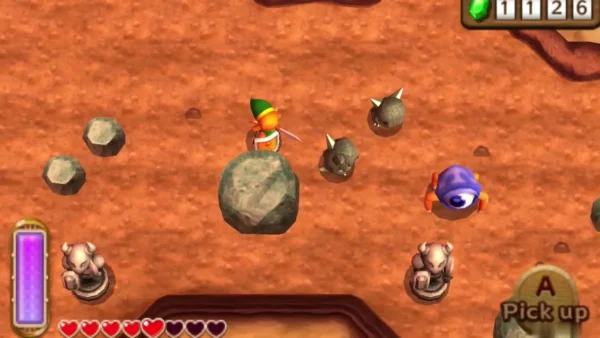 Link beside a large grey rock in a dirt field, the Pick up prompt showing, enemies nearby