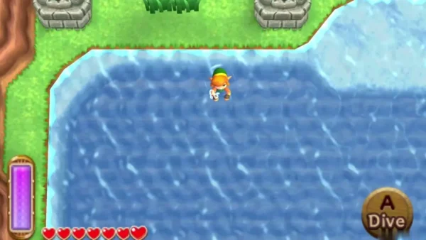 Link swimming in a blue pond with a Dive prompt, stone-head statues on the grass beside it