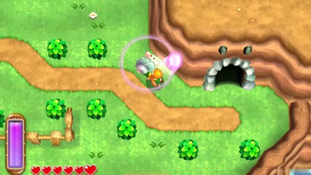 Link merged against a brown cliff near a cave mouth with grey rocks, a lost Maiamai glowing beside him Link merged against a brown cliff near a cave mouth with grey rocks, a lost Maiamai glowing beside him