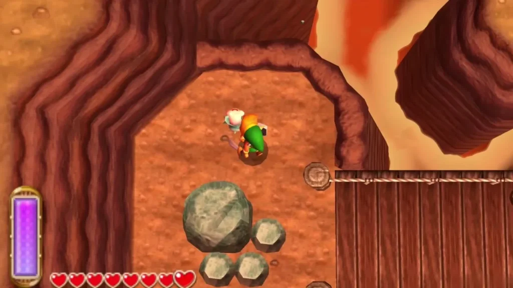 Link on a Death Mountain ledge beside a large rock and three small rocks, a lost Maiamai next to him, a bridge at right Link on a Death Mountain ledge beside a large rock and three small rocks, a lost Maiamai next to him, a bridge at right