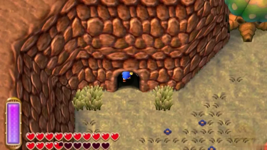 Link stepping into a dark cave mouth in a stone wall, with grass and small blue flowers in the field below Link stepping into a dark cave mouth in a stone wall, with grass and small blue flowers in the field below