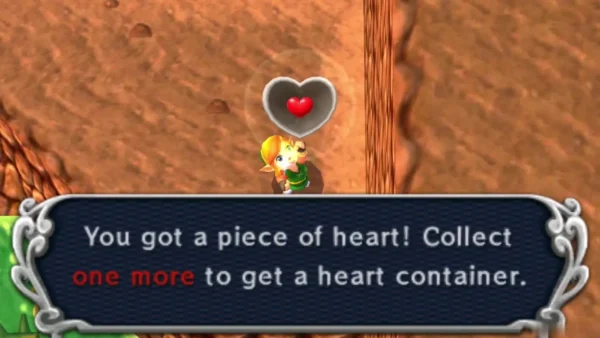 Piece of Heart floating above Link beside a message box saying collect one more for a heart container Piece of Heart floating above Link beside a message box saying collect one more for a heart container