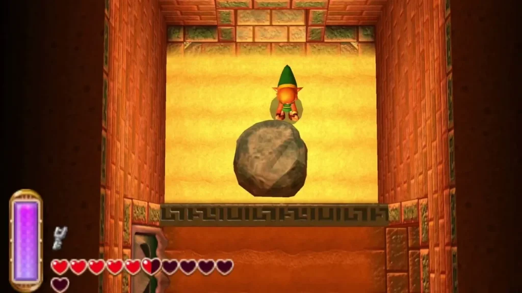 Link stands on the sand above a large grey boulder in a sand room Link stands on the sand above a large grey boulder in a sand room
