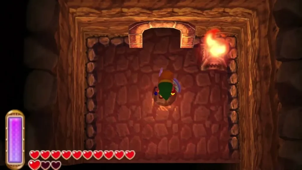 Link in a torch-lit stone cave room with a flame burning on the wall Link in a torch-lit stone cave room with a flame burning on the wall