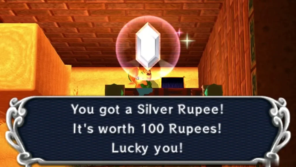 Link holds up a Silver Rupee, with the box saying it is worth 100 Rupees Link holds up a Silver Rupee, with the box saying it is worth 100 Rupees