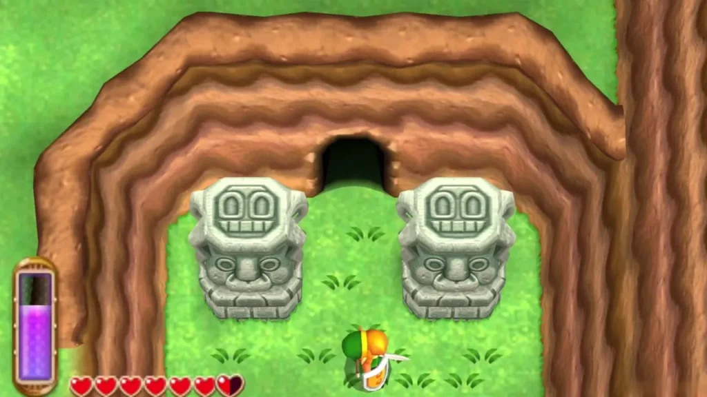 Link standing before the cave entrance between two stone head statues Link standing before the cave entrance between two stone head statues