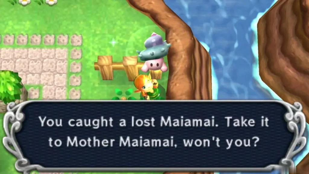 Link lifting a caught Maiamai on grass beside a fence and a cobbled path Link lifting a caught Maiamai on grass beside a fence and a cobbled path