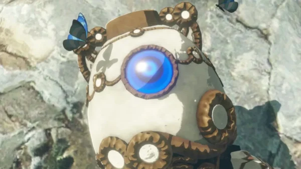 Close-up of Terrako, the little Guardian, with blue butterflies against a stone wall