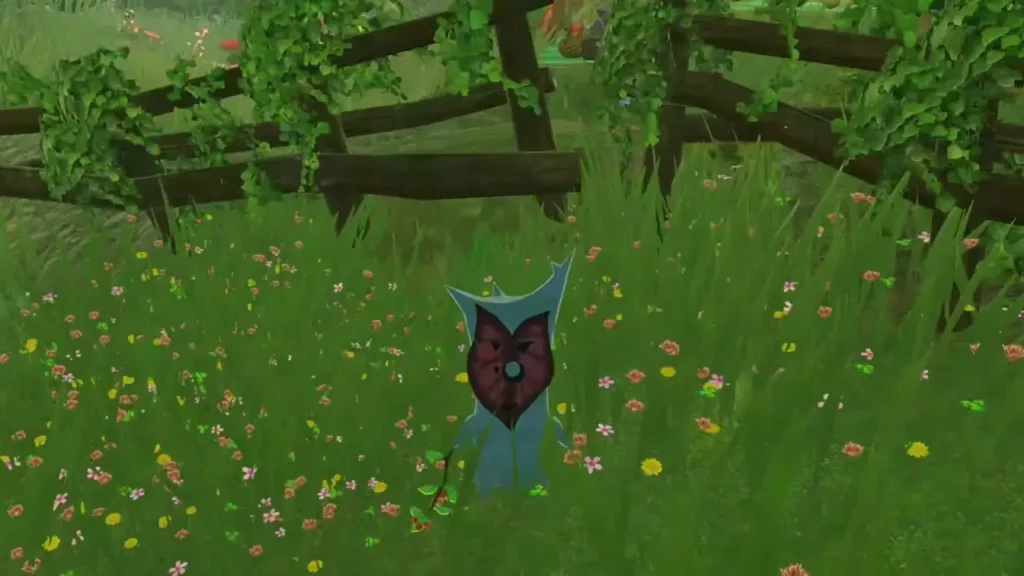 A Korok stands in a flowery meadow beside the fence in the Korok grove