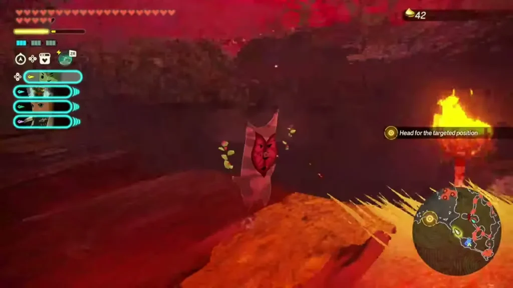 A Korok with a red heart-shaped face stands on the ledge by the torch