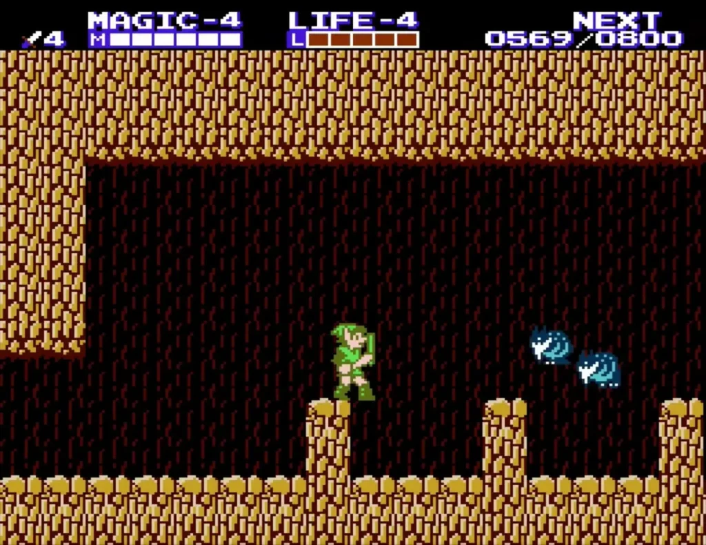 Link in a brown cave with two blue bubble enemies above the floor Link in a brown cave with two blue bubble enemies above the floor