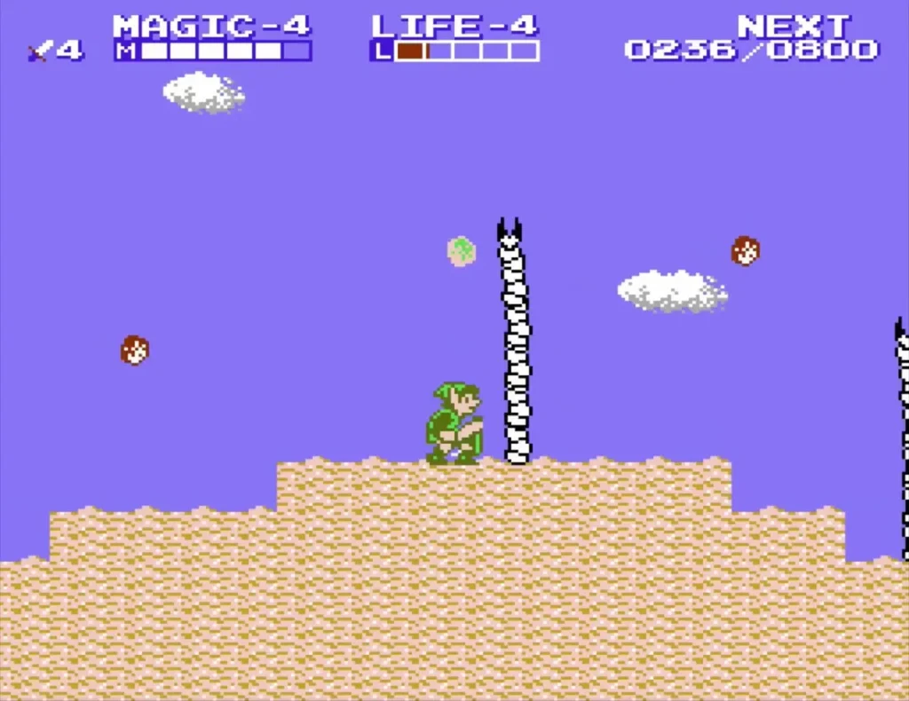 Link on a sand dune beside a striped rock tower in the desert