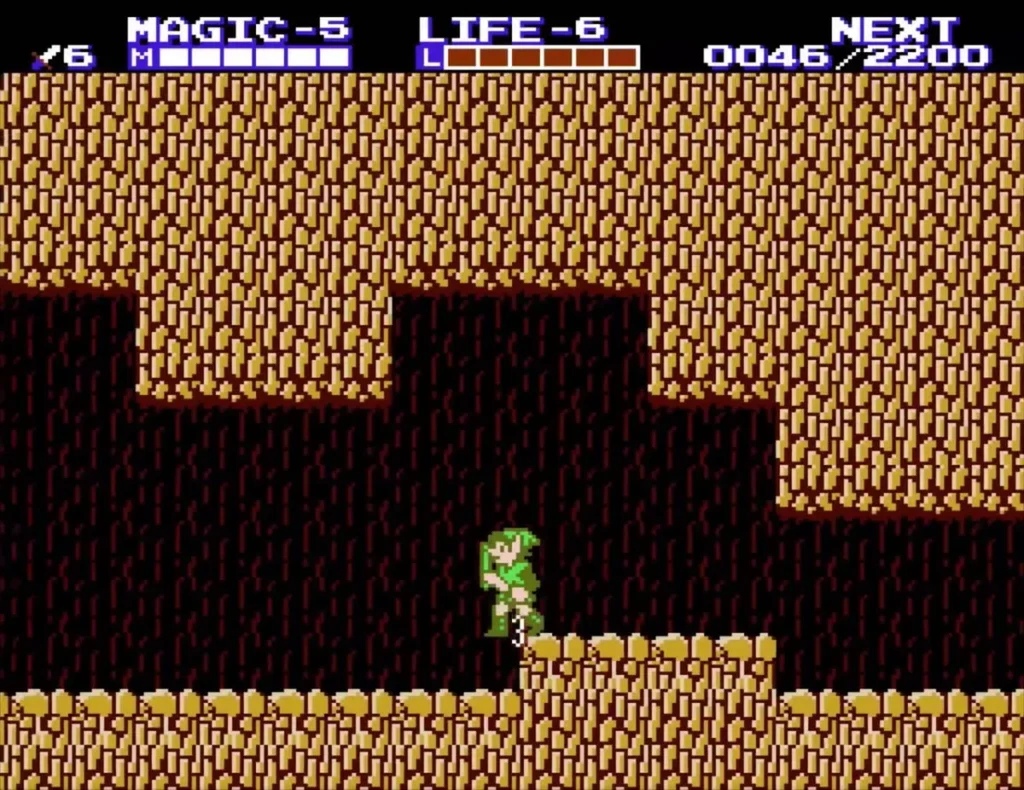 Link climbing the stepped sand ledges inside the sandstone cave