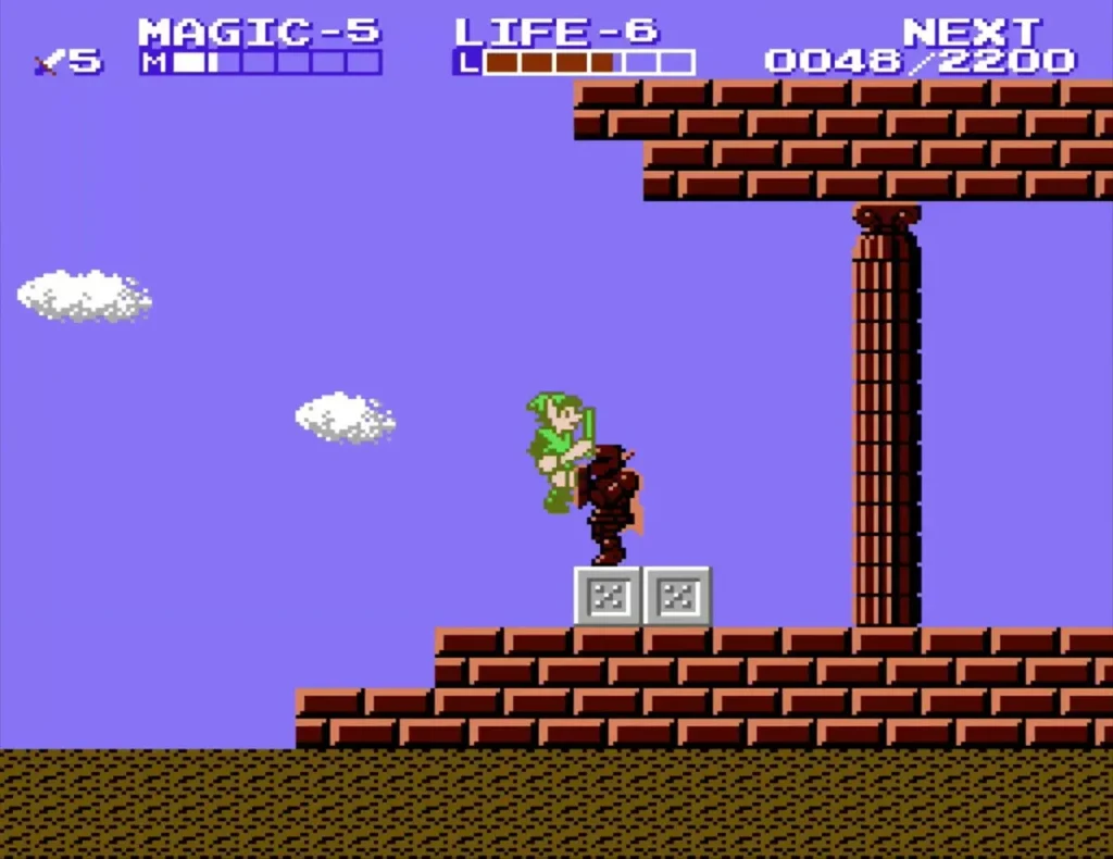 Link beside a brown statue on grey blocks on the brick ledge