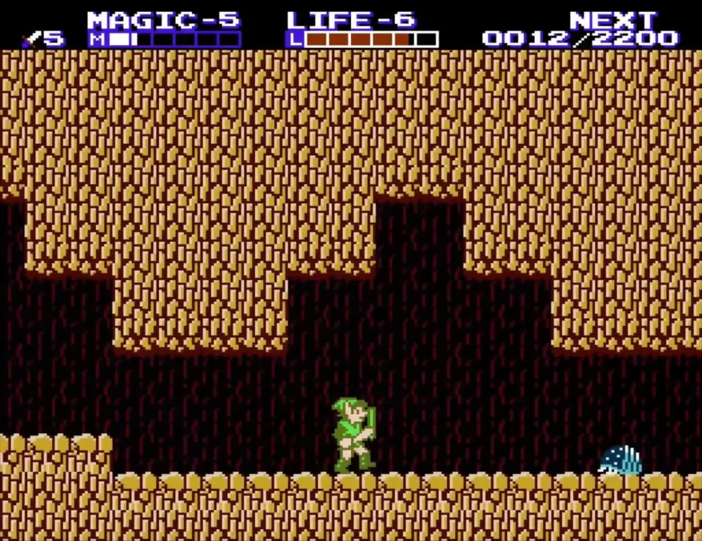 Link on the stepped floor of the sandstone tunnel beside cyan spiked enemies