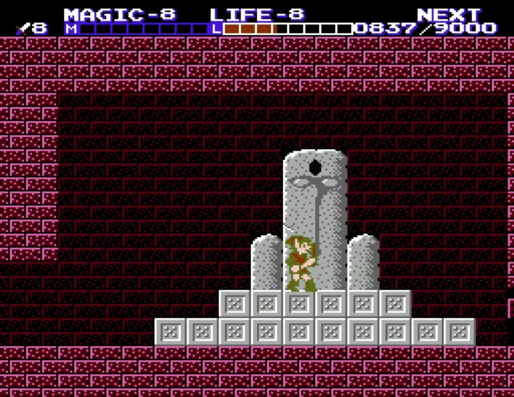 Link standing before the grey statue on its stepped stone base