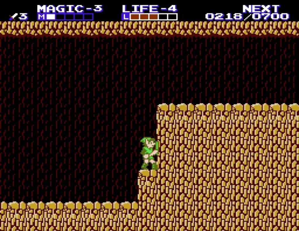 Link at the foot of a taller rock ledge in the cave, climbing up Link at the foot of a taller rock ledge in the cave, climbing up