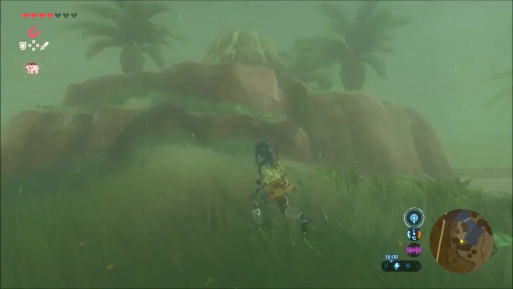Link running through wet grass toward a mound of rocks by the lake