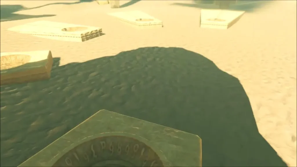 A carved symbol dish in the foreground with other dishes scattered across the sand A carved symbol dish in the foreground with other dishes scattered across the sand