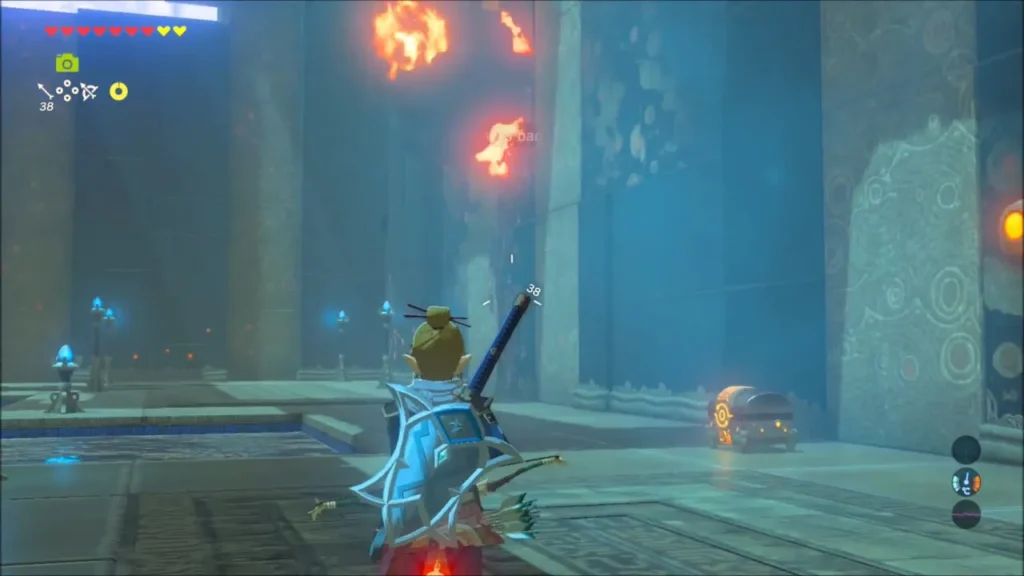 Burning ledges above while a chest sits on the floor by the wall