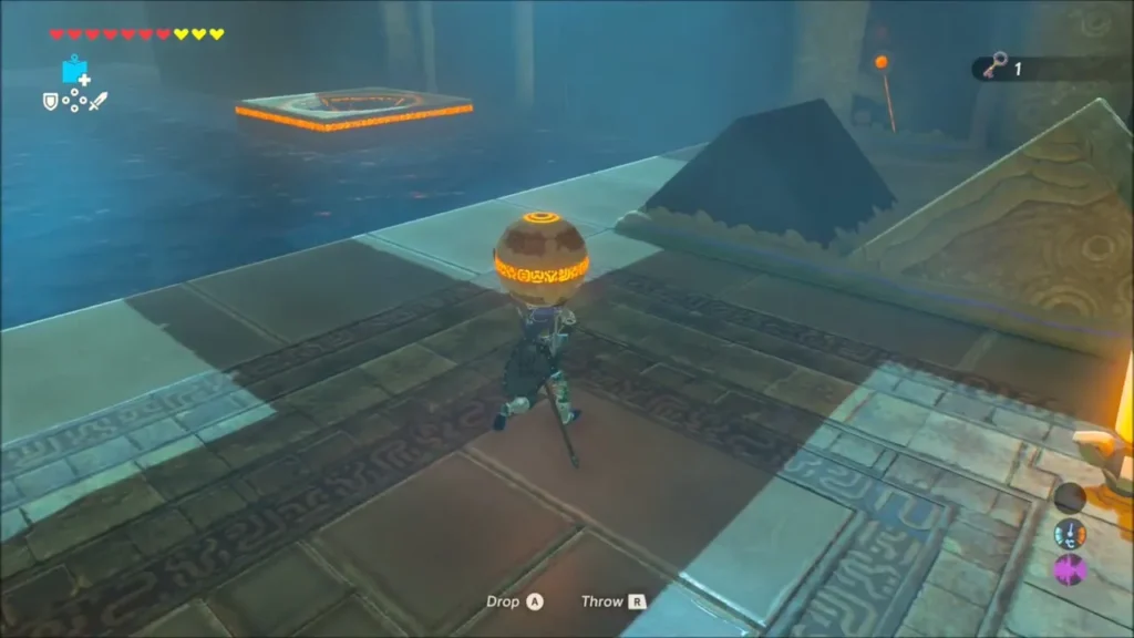 Link carrying a metal ball past the moving platform over water