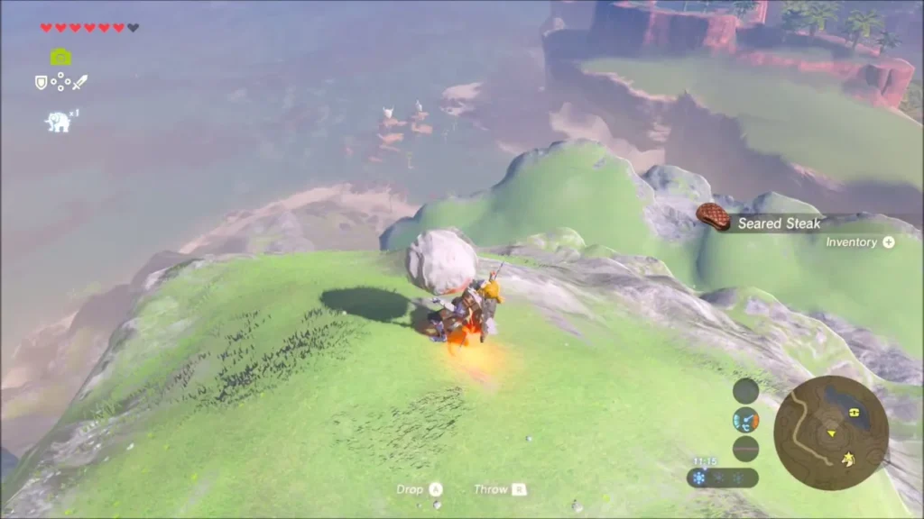 Link lifting the rock on the grassy summit