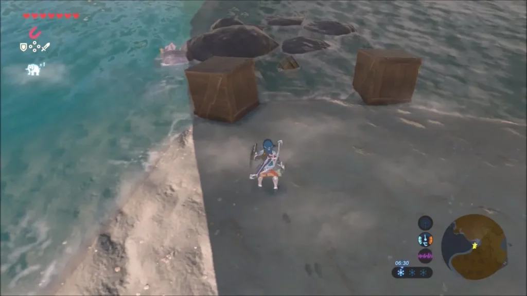 Link standing at the water's edge beside crates and rocks in the shallows